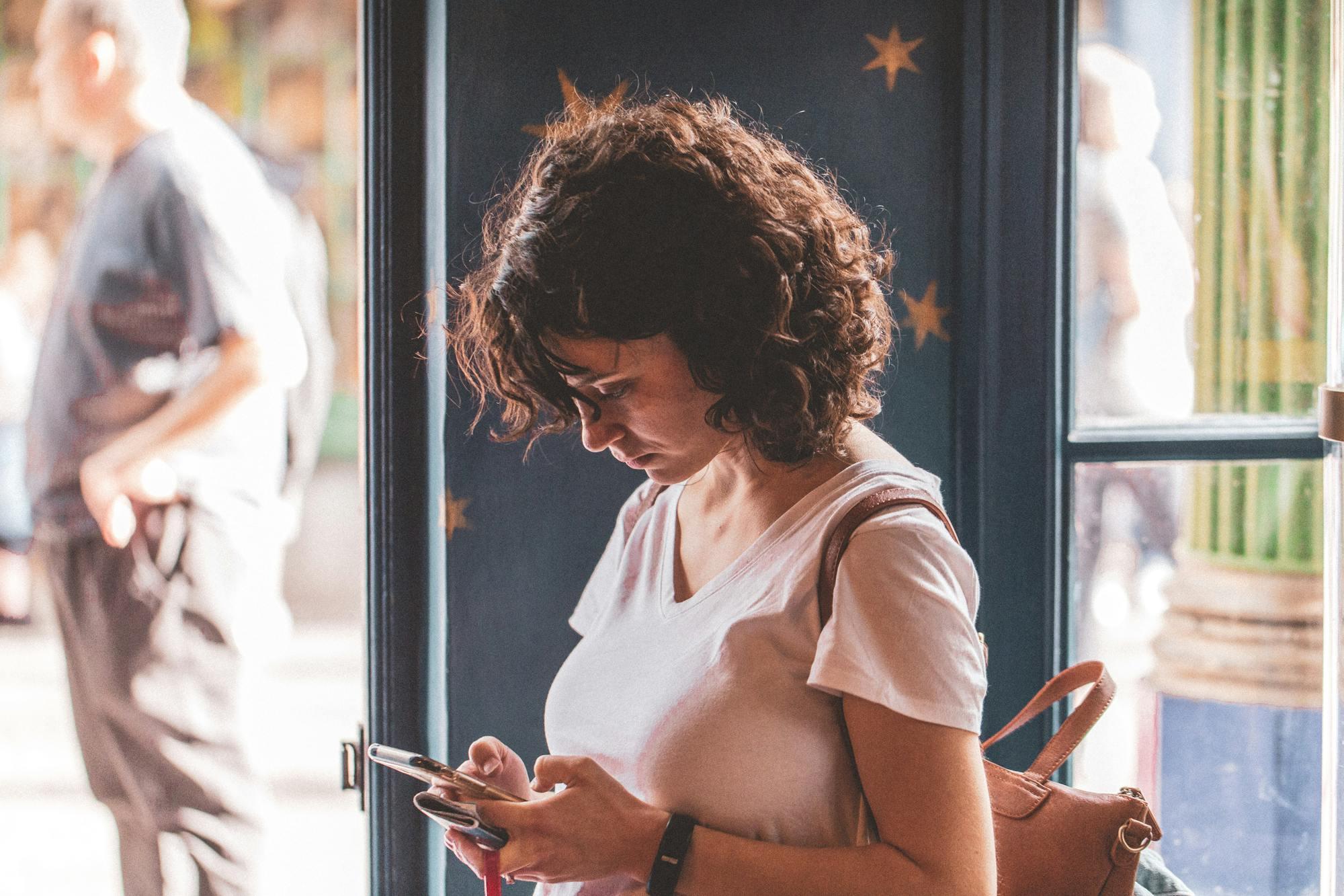 A woman using her phone while researching someone online
